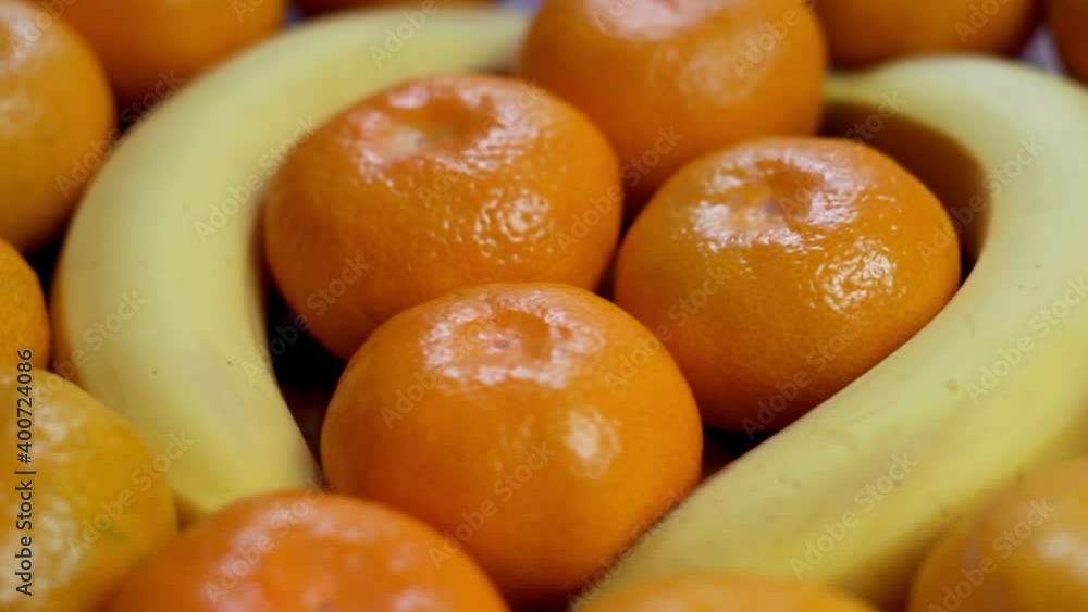 Fresh Unpeeled Tangerines and Bananas, Isolated. Tropical Fruits, Close-Up, Rotation. Background of Tangerines and Bananas. The concept of a Healthy Vitamin Meal and Diet. Fresh Unpeeled Tangerines and Bananas, Isolated. Tropical Fruits, Close-Up, Rotation. Background of Tangerines and Bananas. The concept of a Healthy Vitamin Meal and Diet.