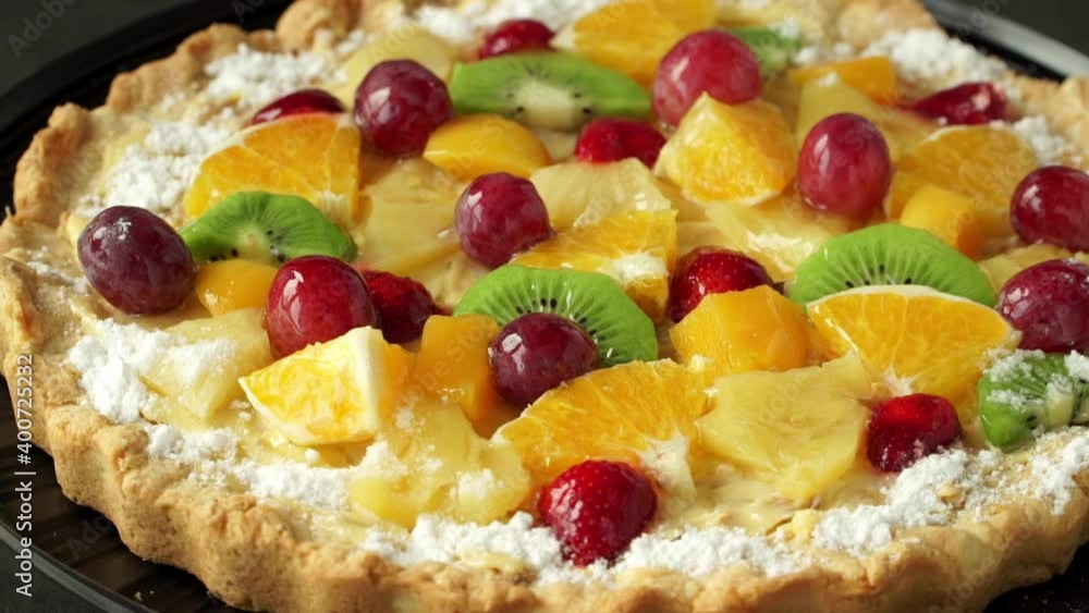 Cake with fresh fruits and ripe berries with cream rotates on tray. Food dessert background. Bakery and pastry shop concept Cake with fresh fruits and ripe berries with cream rotates on tray. Food dessert background. Bakery and pastry shop concept