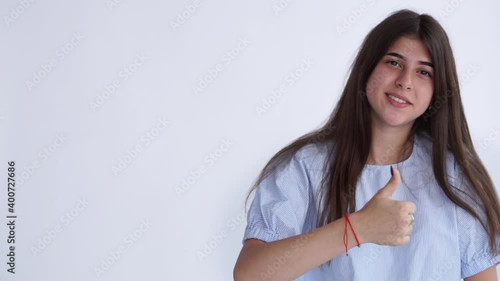 Cute young woman shows cool gesture with her thumb. Cute young woman shows cool gesture with her thumb.