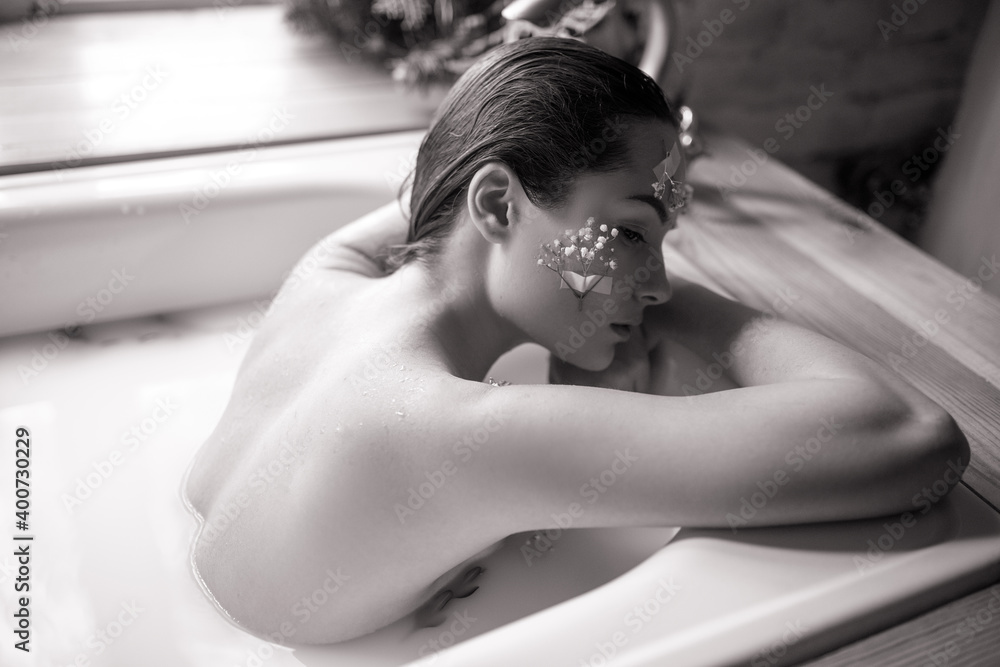 Woman takes a bath with milk and flowers. Woman takes a bath with milk and flowers.