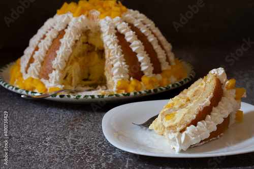 Zuccotto with mango. Traditional Italian cake with cream and mango on top, on a gray background photo