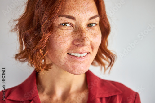 natural redhead woman with freckles posing at camera isolated in studio, natural beauty, people and lifestyle concept