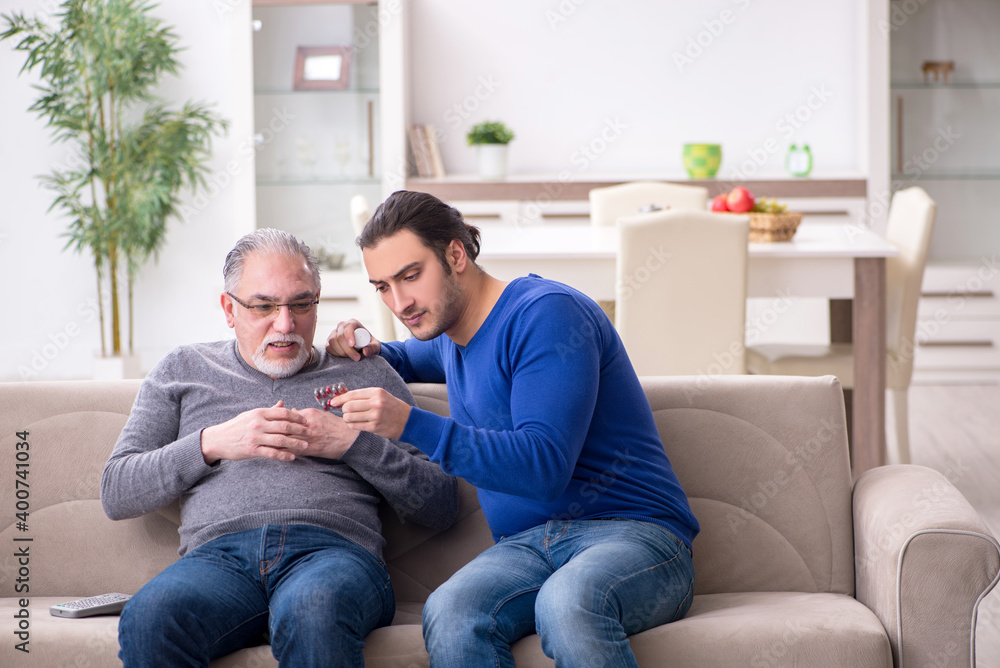 Young man looking after his sick father Young man looking after his sick father