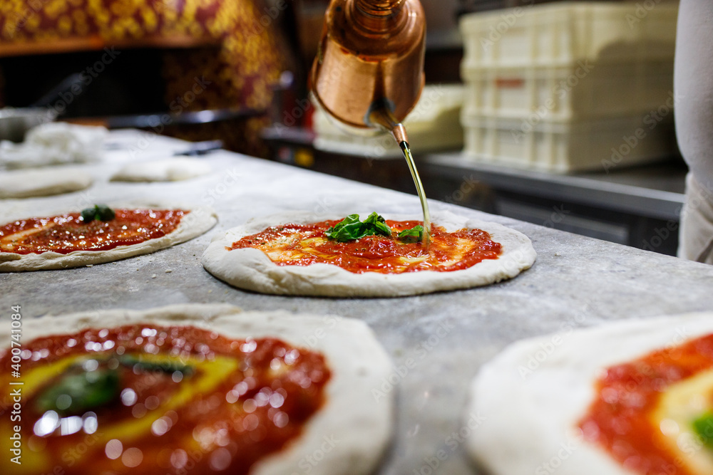 Pizza cruda napoletana con sugo di pomodoro, olio e basilico pronta per  essere infornata Stock-Foto | Adobe Stock