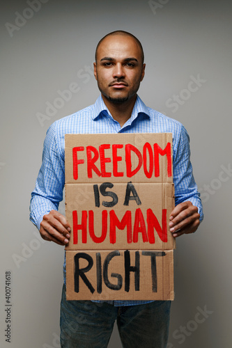 'Freedom is a human right' placard in hands of protester man