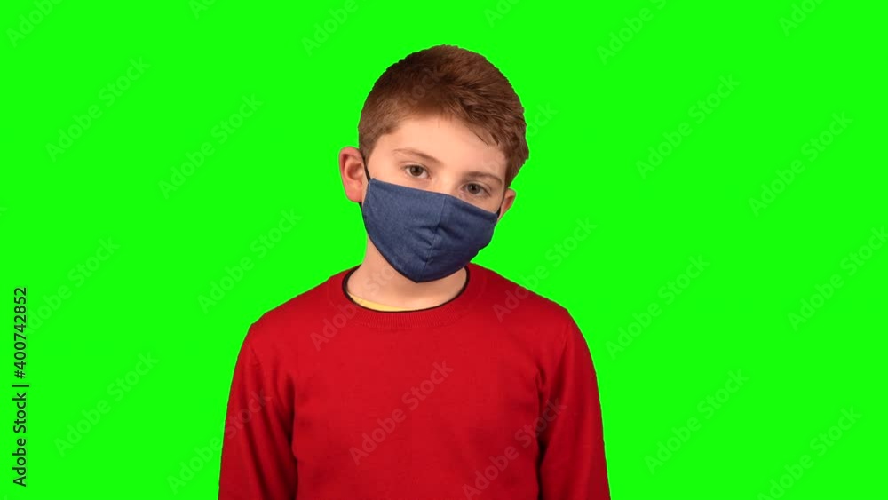 Close up kids boy in medical mask looks sadly at camera on green screen background studio Close up kids boy in medical mask looks sadly at camera on green screen background studio
