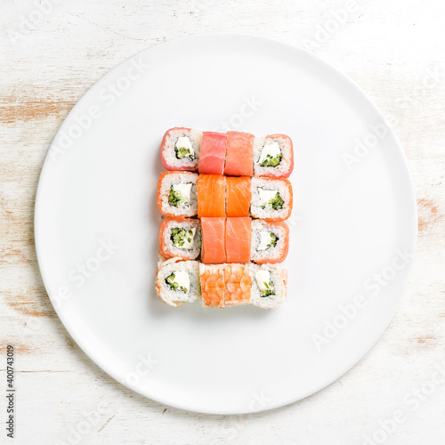 Sushi rolls with salmon on a white plate. Top view. On a white background.