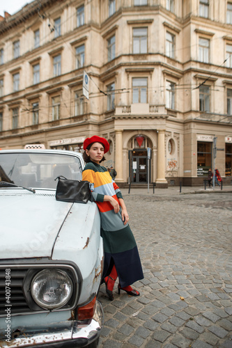 young woman in a red beret dressed in parisian style walks the streets of the old city