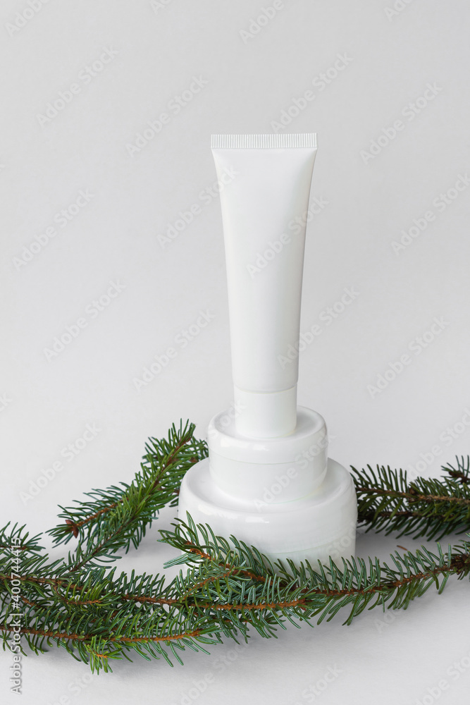Organic cosmetics. White jars and tubes with cream or lotion, tonic next to green branches of spruce, pine, fir. Mock ap. Vertical orientation. Bio natural body and face care. Place for text Organic cosmetics. White jars and tubes with cream or lotion, tonic next to green branches of spruce, pine, fir. Mock ap. Vertical orientation. Bio natural body and face care. Place for text