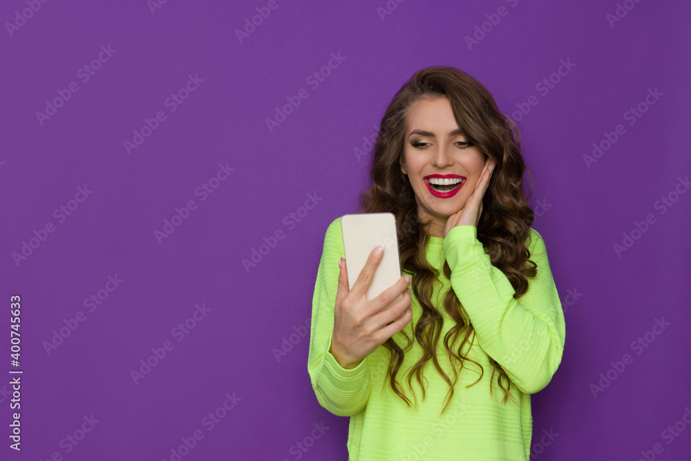 Laughing Young Woman Is Holding Telephone, Looking At It. Laughing Young Woman Is Holding Telephone, Looking At It.