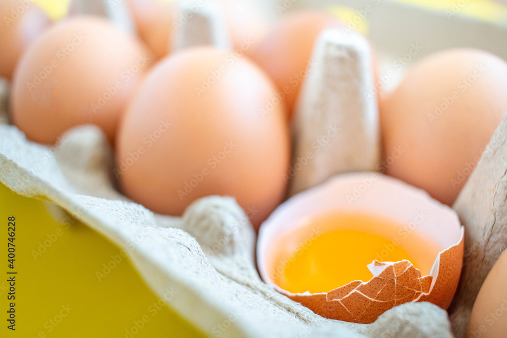 Closeup cracked brown eggs Arranged in a paper box Buy from supermarket Placed on a yellow background Closeup cracked brown eggs Arranged in a paper box Buy from supermarket Placed on a yellow background