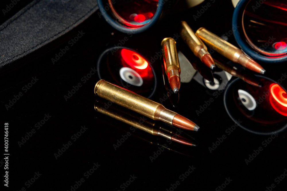 Military binoculars and cartridges on mirror background Military binoculars and cartridges on mirror background