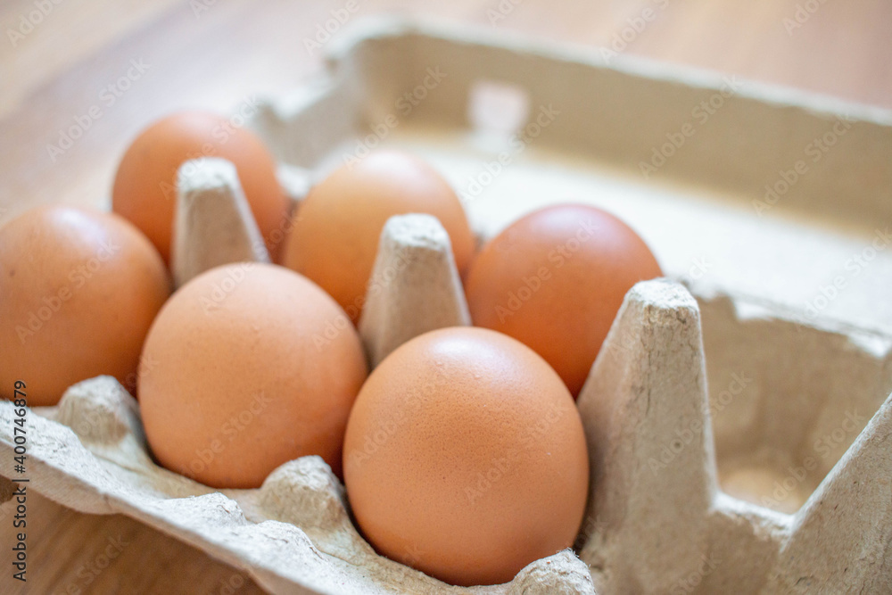 Closeup brown eggs in paper box There is not a full box of eggs. Buy from the supermarket, put it on the wooden floor. Closeup brown eggs in paper box There is not a full box of eggs. Buy from the supermarket, put it on the wooden floor.