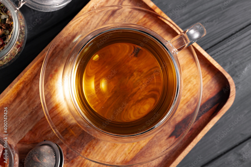 Glass cup of tea on wooden board
