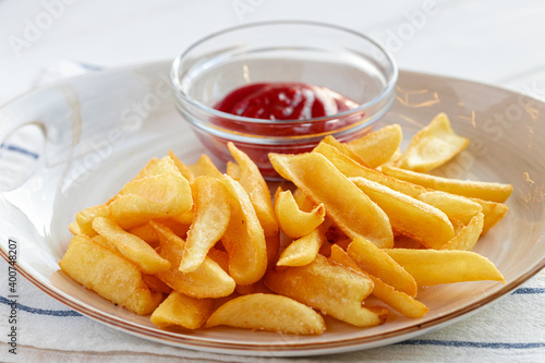 French fries potatoes in plate with sauce on wooden table