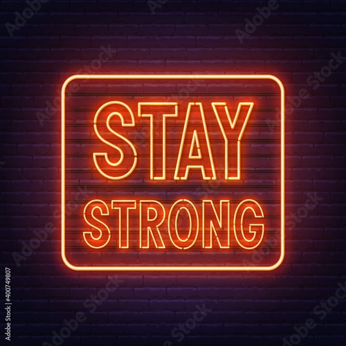 Stay strong neon quote on a brick wall. Inspirational glowing lettering.