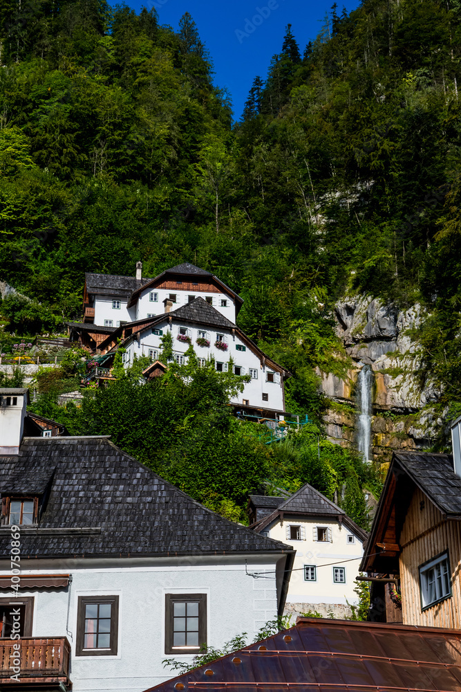 Spectacular Buildings Beneath Waterfall In The Lakeside Town Hallstatt in Austria