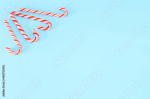 Light blue Christmas background decorated with candy canes. Place for text or Christmas greetings.