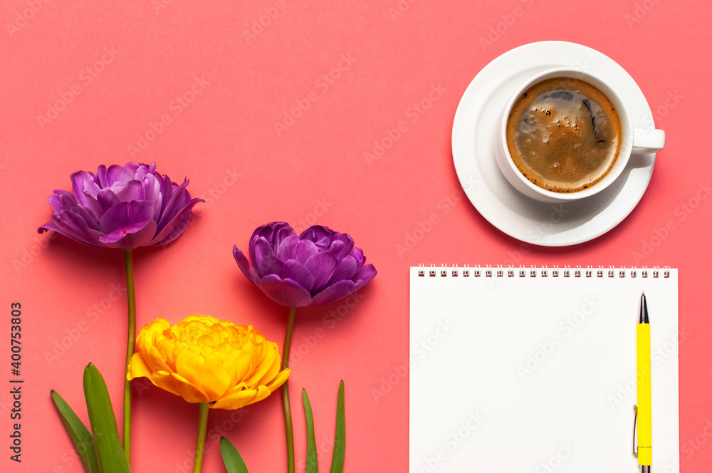 Flat lay Spring flowers Yellow lilac tulips cup of coffee white blank album notebook writing pen on pink background. Lovely greeting card for March 8 Mothers day holiday birthday. Woman working desk