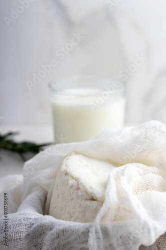 Soft goat cheese with a glass of milk. Adyghe cheese on a marble table