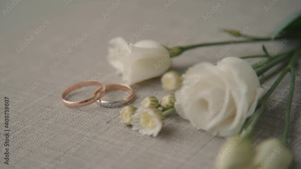 Wedding rings and bridal flowers. Romantic composition of golden engagement ring and elegant white Wedding rings and bridal flowers. Romantic composition of golden engagement ring and elegant white