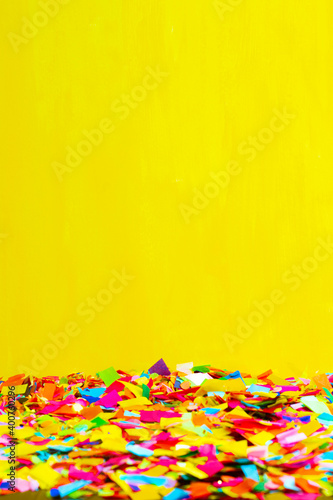 Close-up of a ground full of confetti with a yellow background.