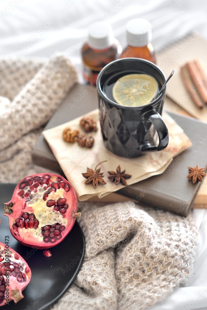 Natural  flu home remedies: hot tea cups with lemon and walnut and pomegranate to boost immune system. Natural healthy food and hot drink ingredients for immunity stimulation and against viruses.