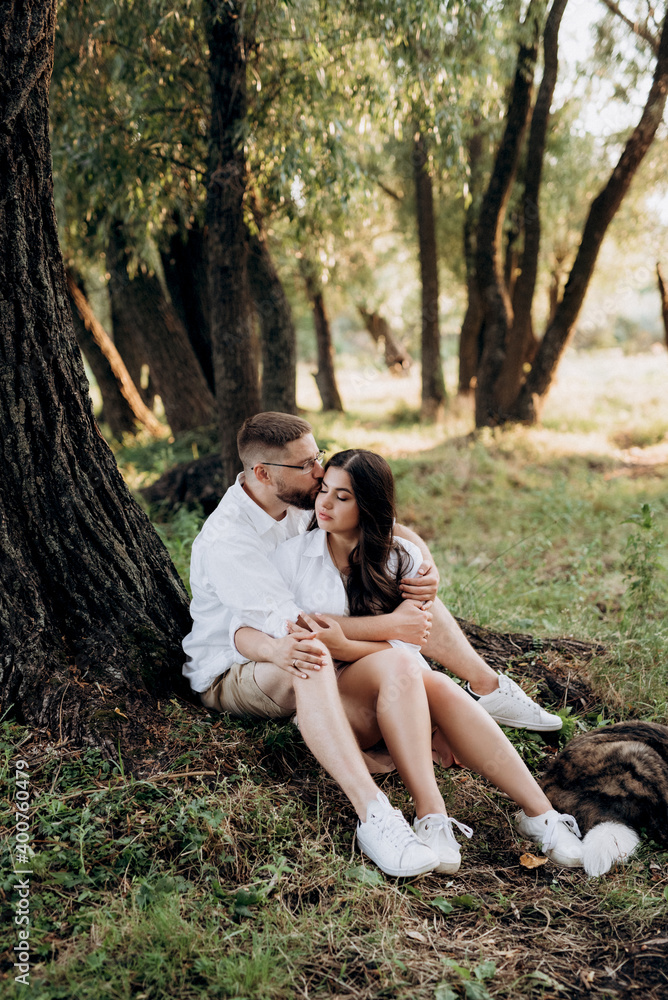 Fototapeta premium young couple in love a guy with a beard and a girl with dark hair in light clothes