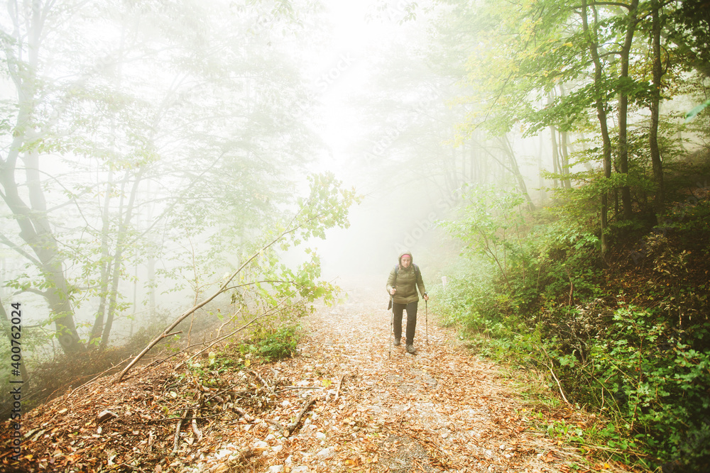 Hike Woman walking on foggy autumn day through misty forest. Healthy lifestyle. Hike Woman walking on foggy autumn day through misty forest. Healthy lifestyle.