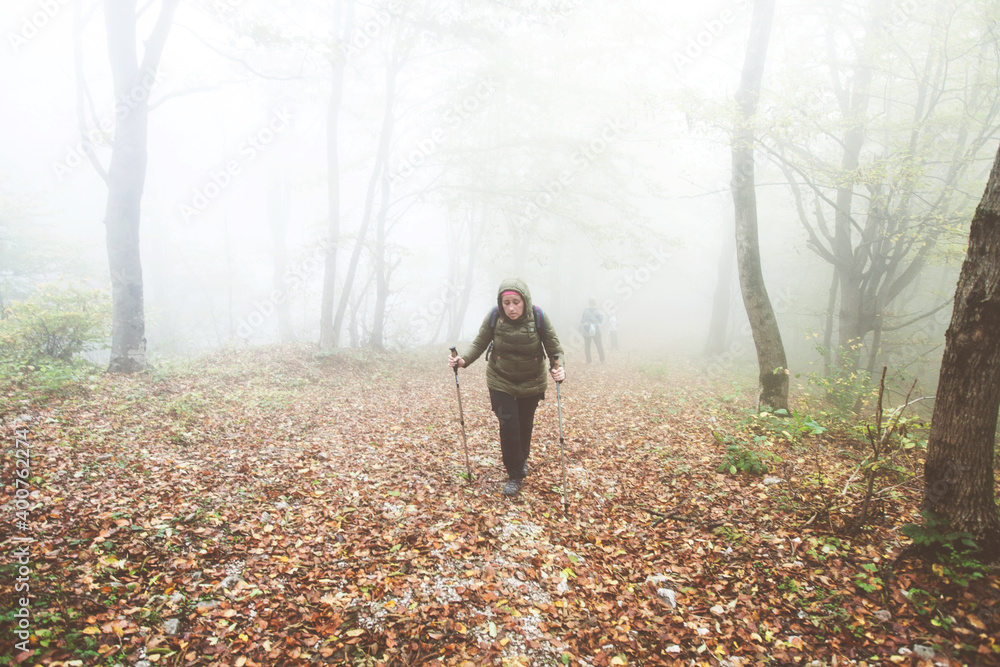 Hike Woman walking on foggy autumn day through misty forest. Healthy lifestyle. Hike Woman walking on foggy autumn day through misty forest. Healthy lifestyle.