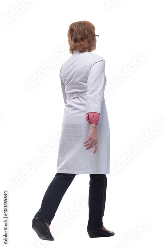 Full length studio shot of beautiful mature woman in white coat and glasses walking photo