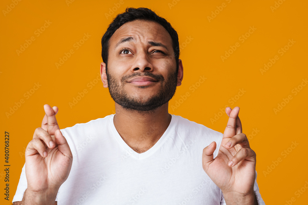 Asian unhappy man holding fingers crossed for good luck Asian unhappy man holding fingers crossed for good luck