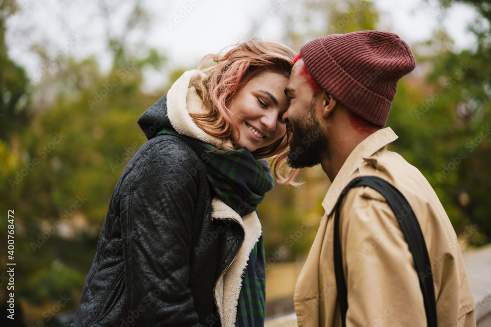 Fototapeta premium Multinational beautiful happy couple smiling while standing head to head