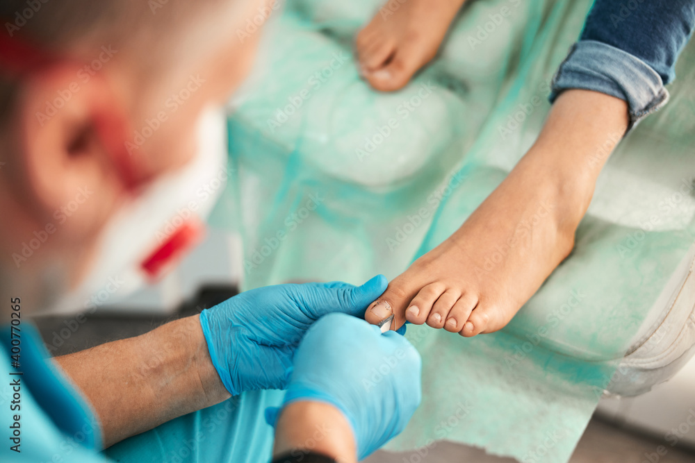 Competent podologist using sterile instrument while working