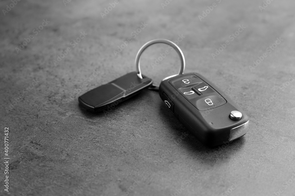 Modern car flip key with trinket on grey background Modern car flip key with trinket on grey background