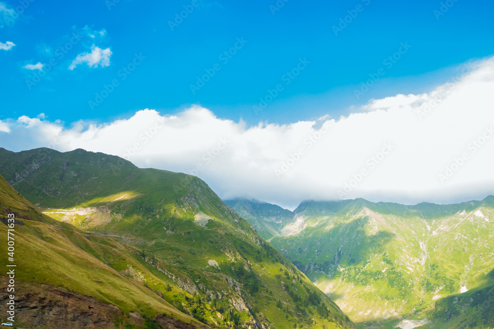 Romanian Carpathian mountains on a summer sunny day. Amaizing view on the mountains and cloudy sky from Transfagarasan alpine mountain road, Fagaras Mountains, Transylvania, Romania. Travel backdrop