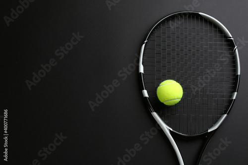 Tennis racket and ball on black background, top view. Space for text © New Africa