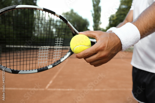 Sportsman preparing to serve tennis ball at court, closeup © New Africa