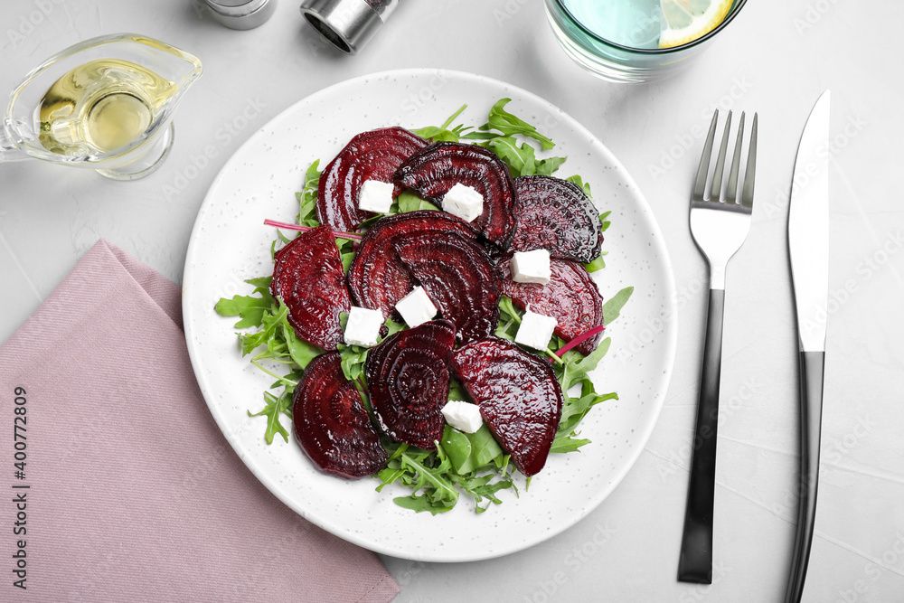 Roasted beetroot slices with feta cheese and arugula served on light grey table, flat lay Roasted beetroot slices with feta cheese and arugula served on light grey table, flat lay