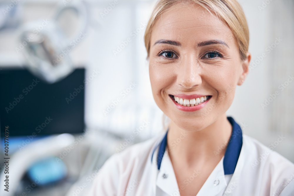 Cheerful female dentist having good time at work Cheerful female dentist having good time at work