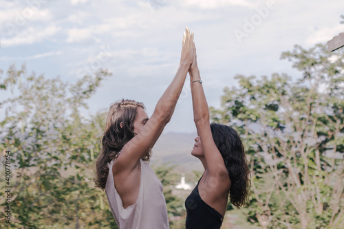 White hippie couple doing healthy meditation yoga and relationship body practice during sunset time in the nature