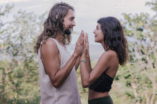 White hippie couple doing healthy meditation yoga and relationship body practice during sunset time in the nature