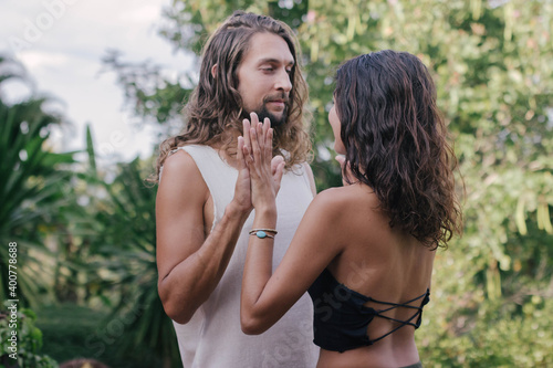 White hippie couple doing healthy meditation yoga and relationship body practice during sunset time in the nature