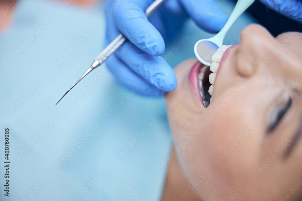 Merry young woman having teeth treated in clinic Merry young woman having teeth treated in clinic