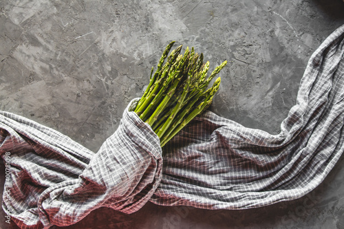 Asparagus in a kitchen towel on a gray background. healthy food