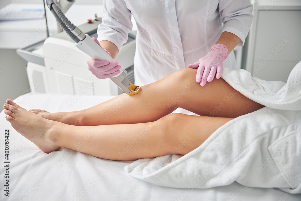 Fototapeta premium Dermatologist removing unwanted hair on female legs