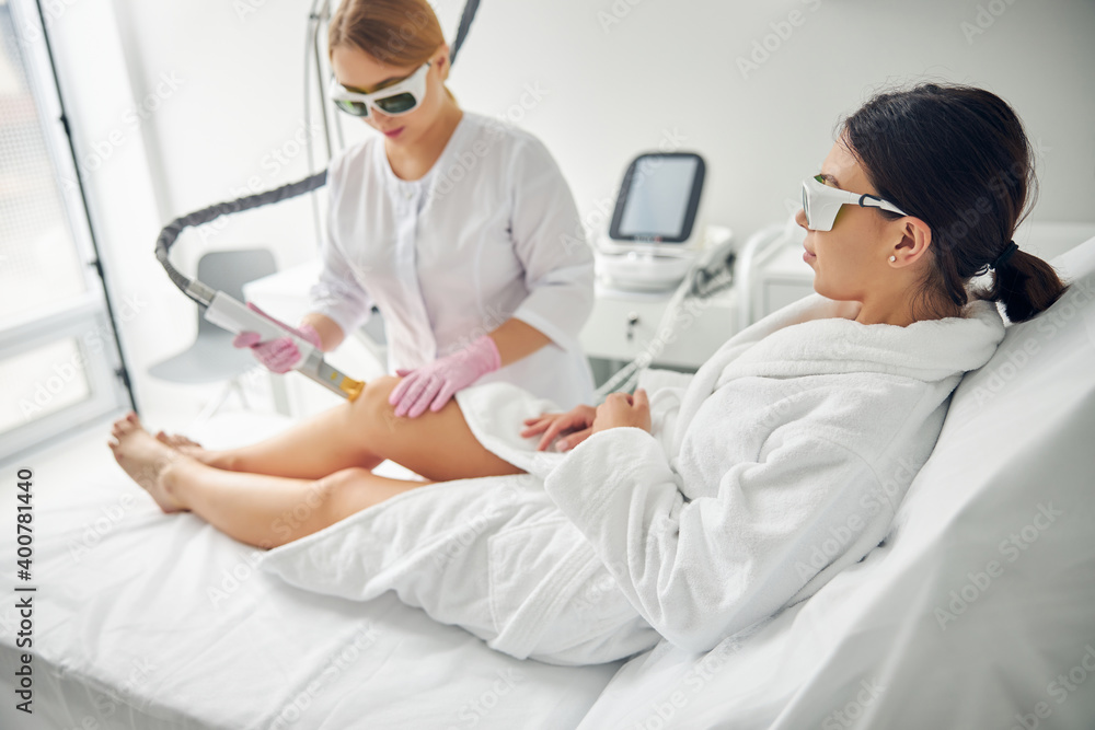 Relaxed young woman undergoing a cosmetic procedure Relaxed young woman undergoing a cosmetic procedure