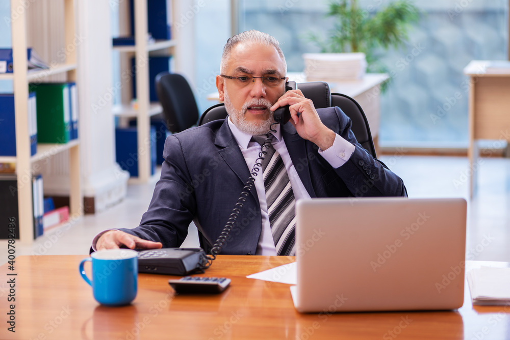 Old businessman employee working in the office Old businessman employee working in the office