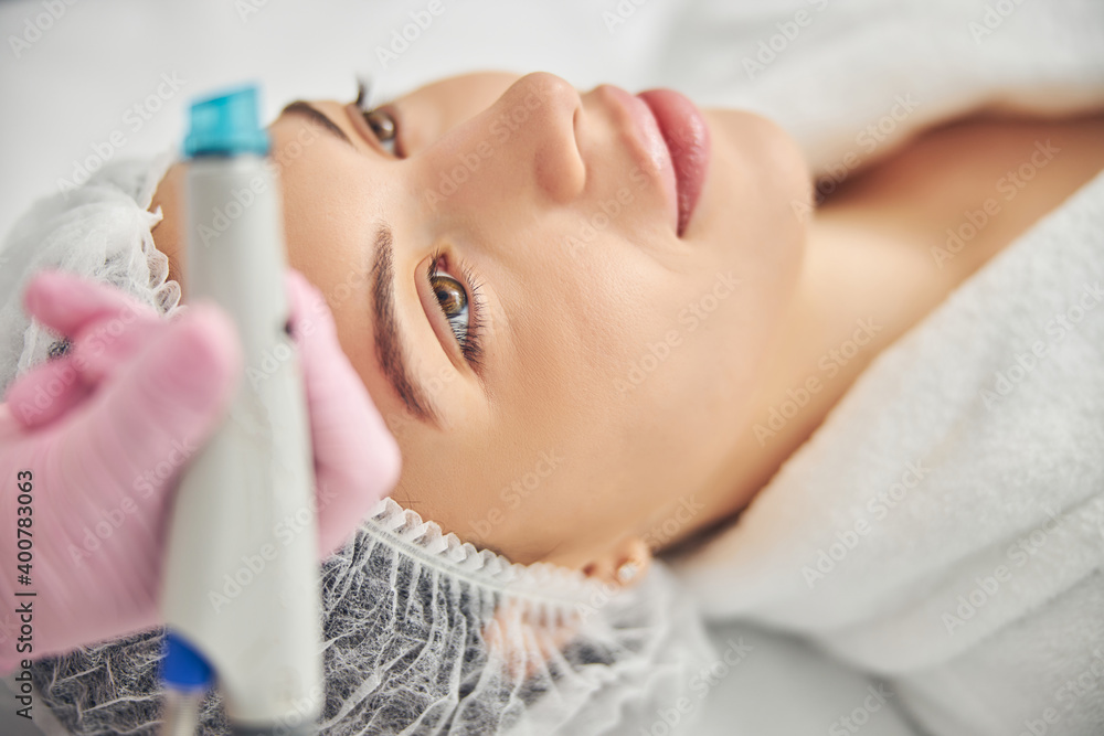 Caucasian woman relaxing during the hydrodermabrasion procedure Caucasian woman relaxing during the hydrodermabrasion procedure