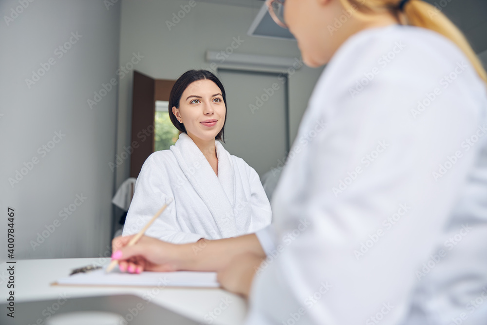 Obraz premium Spa client looking at a blonde lady doctor